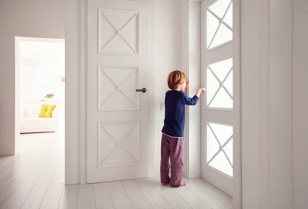 Niño abre la puerta en casa —  Fotos de Stock