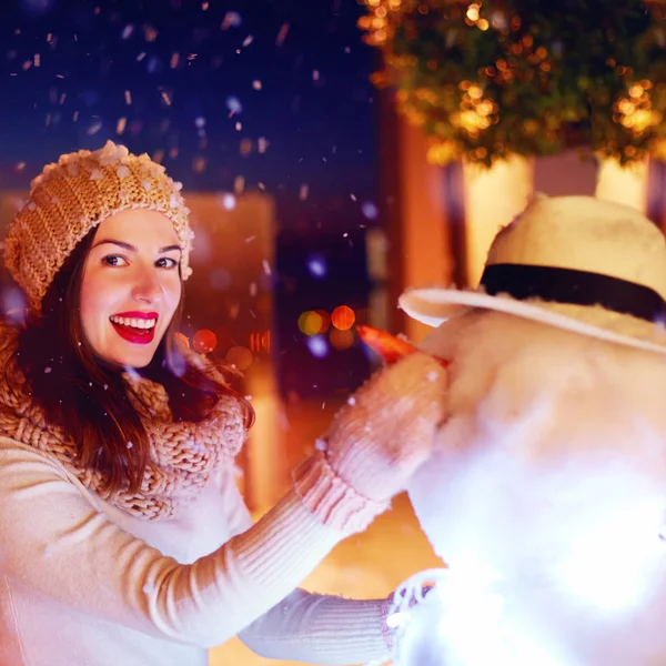 Bella donna felice facendo pupazzo di neve sotto la neve magica inverno — Foto Stock