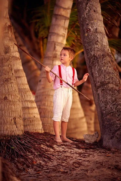 Elegante ragazzo carino esplorare palmeto tropicale — Foto Stock