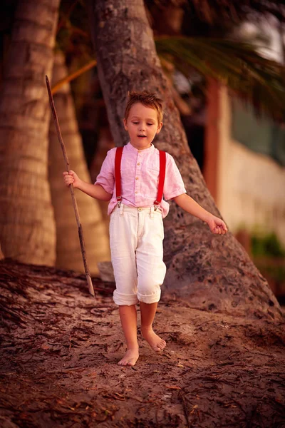 Elegante ragazzo carino esplorare palmeto tropicale — Foto Stock