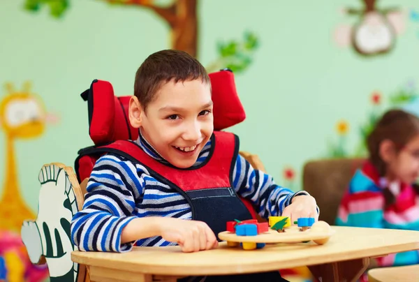 Веселий хлопчик з інвалідністю в реабілітаційному центрі для дітей з особливими потребами — стокове фото