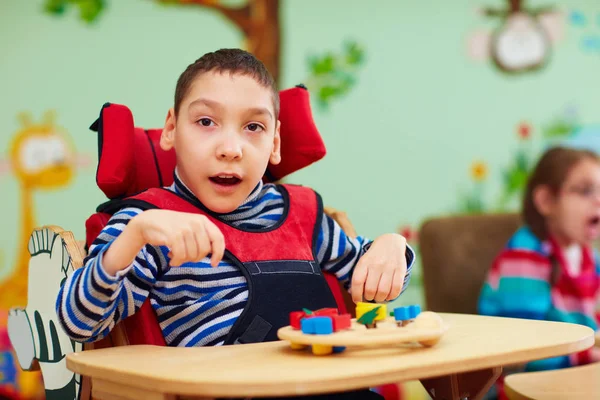 Veselý kluk s handicapem na rehabilitační centrum pro děti se speciálními vzdělávacími potřebami — Stock fotografie