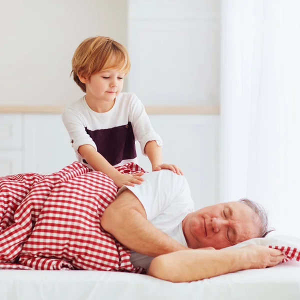 Cute grandson gently wakes hid grandpa up — Stock Photo, Image