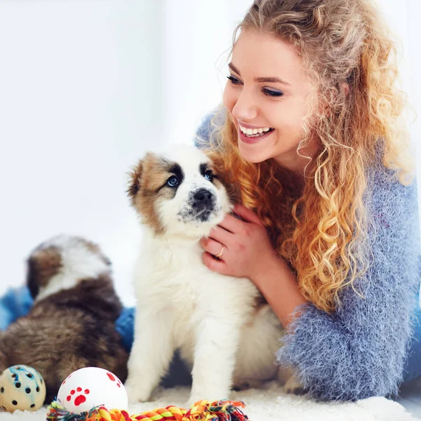 Vacker kvinna leker med söt kaukasiska herde valpar — Stockfoto