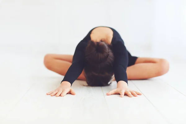 Linda chica hace ejercicios de estiramiento en la clase de baile en la escuela de salón —  Fotos de Stock