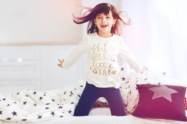 Schattig gelukkig meisje zingen in de slaapkamer in de ochtendzon licht — Stockfoto