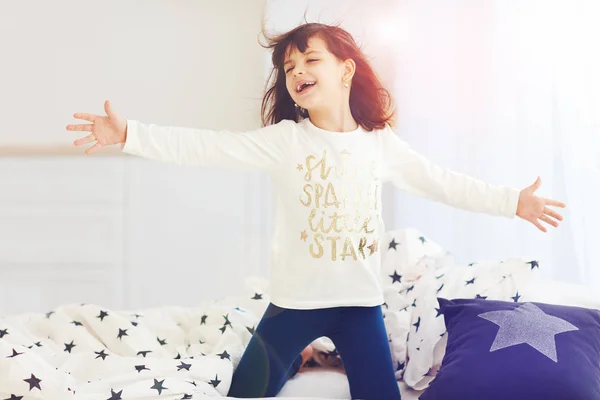 Schattig gelukkig meisje zingen in de slaapkamer in de ochtendzon licht — Stockfoto