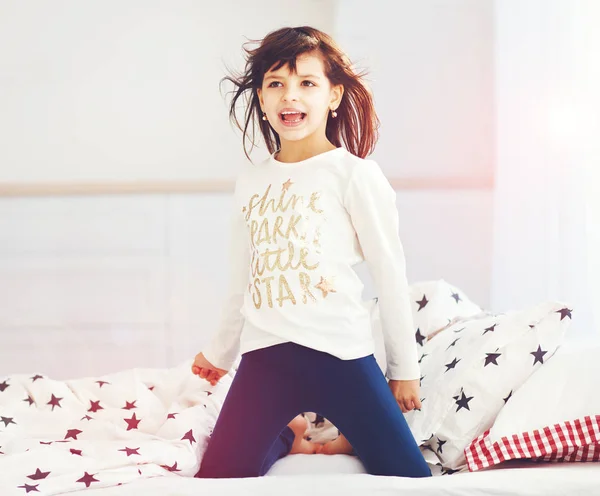 Happy vigorous young girl wakes up in the morning sun light, singing in bedroom — Stock Photo, Image