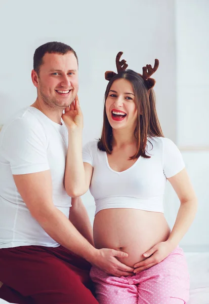 Engraçada grávida casal no pijama se divertindo em casa — Fotografia de Stock