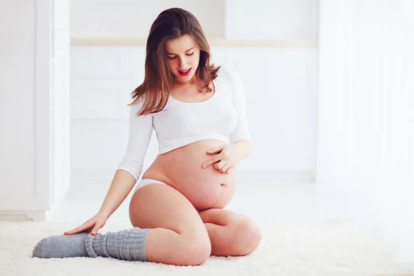 Beautiful pregnant woman strokes her tummy — Stock Photo, Image