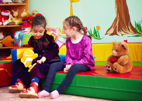 Χαριτωμένα κορίτσια συνομιλώντας και παίζοντας στο νηπιαγωγείο για παιδιά με ειδικές ανάγκες — Φωτογραφία Αρχείου