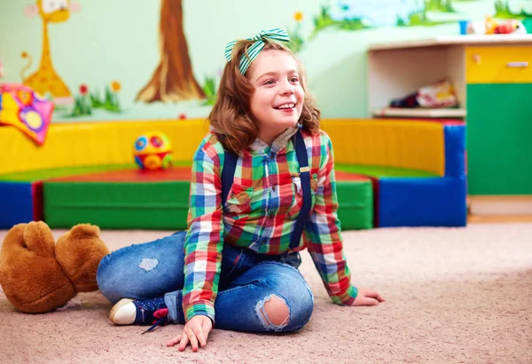 Linda chica feliz jugando en el jardín de infantes para niños con necesidades especiales — Foto de Stock