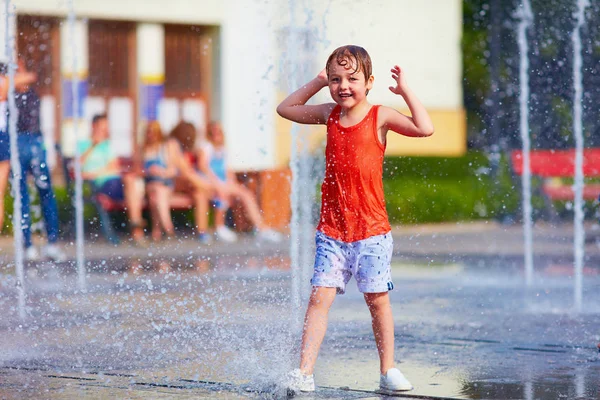 Podekscytowany chłopiec zabawy między strumieniem wody, fontanny. Lato i — Zdjęcie stockowe