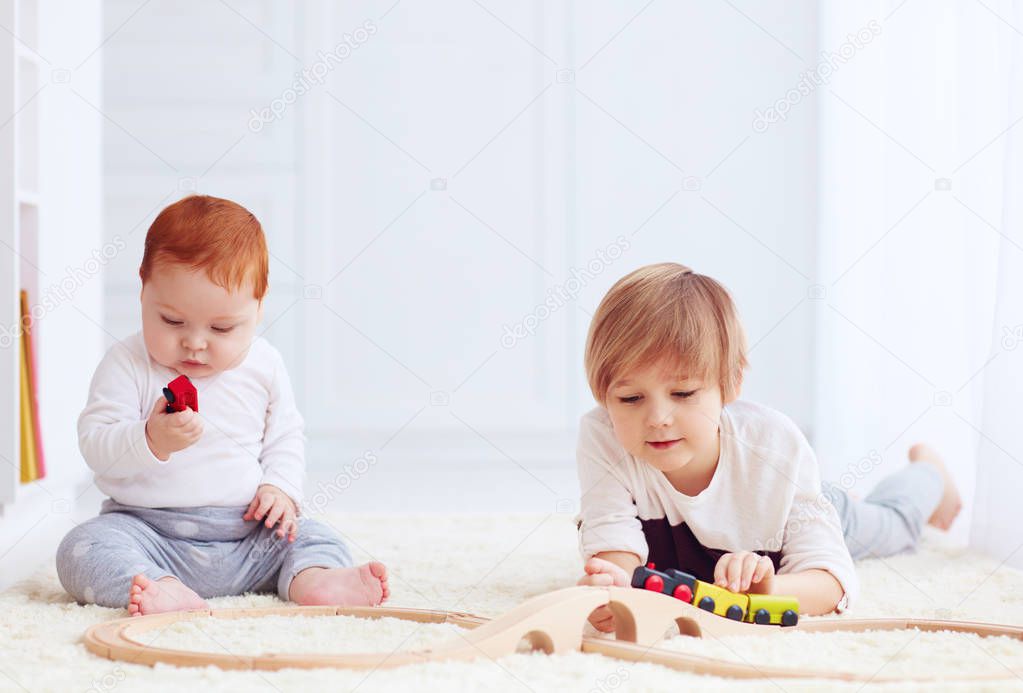 cute kids playing with toy railway road at home