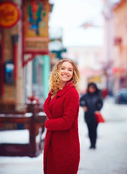 beautiful happy woman walking on crowded city street in winter
