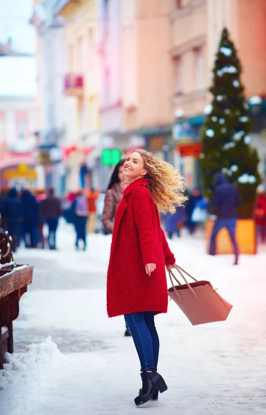 Щаслива красива жінка, що йде по переповненій вулиці взимку — стокове фото