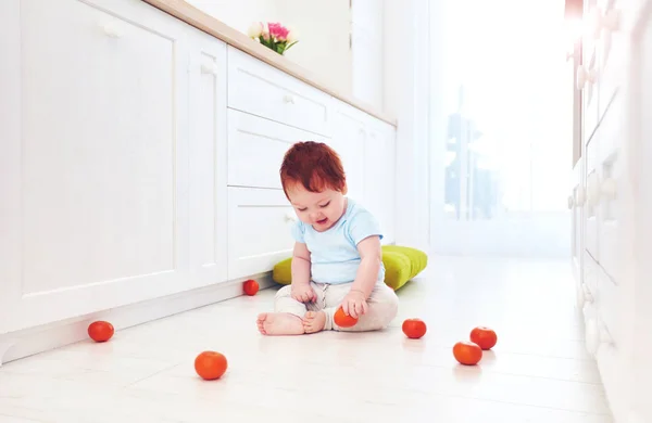 Lindo jengibre bebé jugando en la cocina brillante, en casa —  Fotos de Stock