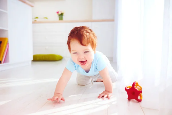 Bonito gengibre bebê menino rastejando no chão em casa — Fotografia de Stock