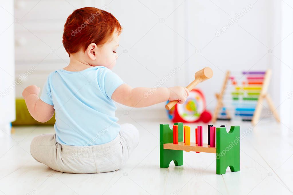 cute infant baby playing with wooden hammer block toy