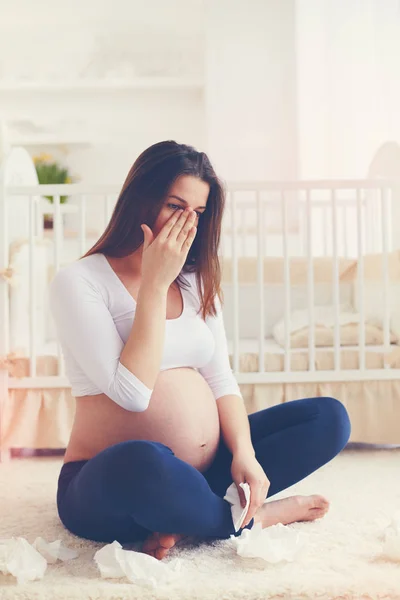 Upset pregnant woman crying in nursery room at home — Stock Photo, Image