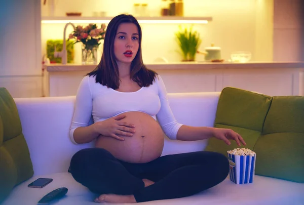 Mulher grávida assistindo filme emocionante em casa sozinha — Fotografia de Stock