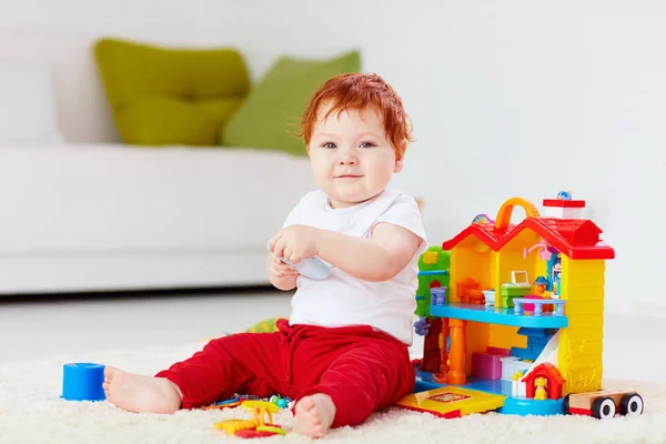 Uroczy rudzielec niemowlę dziecko bawi się zabawkami w domu — Zdjęcie stockowe