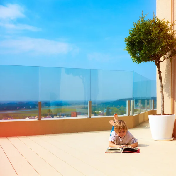 Молодий хлопчик розслабляється на верхній терасі даху, літній час — стокове фото