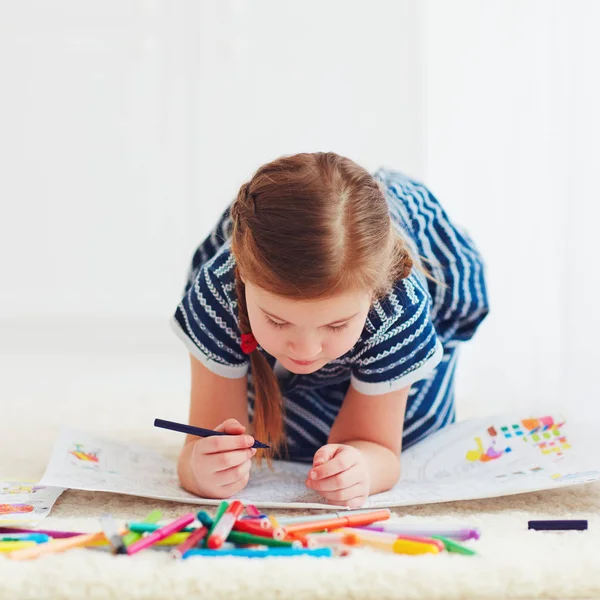 Portret van leuk gelukkig meisje tekening, terwijl het opleggen van tapijt — Stockfoto