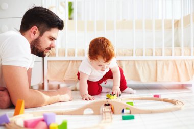 mutlu baba bebek bebek çocuk ile güneşli çocuk odasında oynarken