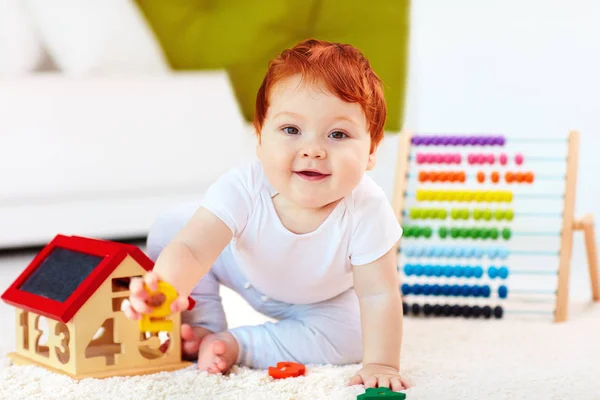 Bebê ruiva bonito brincando com brinquedos de madeira, numerais, aprendendo a contar — Fotografia de Stock