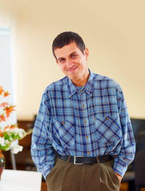 portrait of cheerful adult man with disability in rehabilitation center clipart