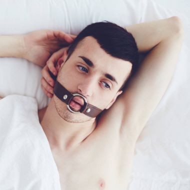handsome man with a face strap laying in bed clipart