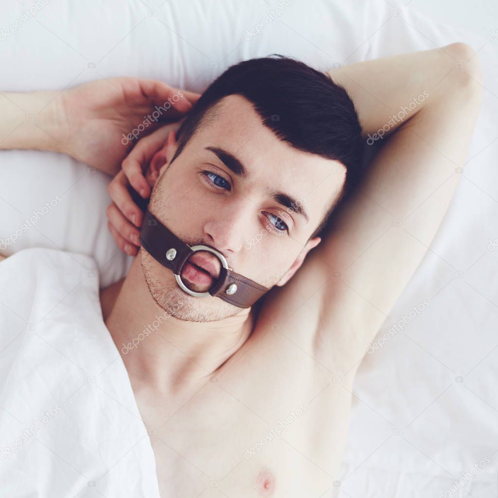 handsome man with a face strap laying in bed
