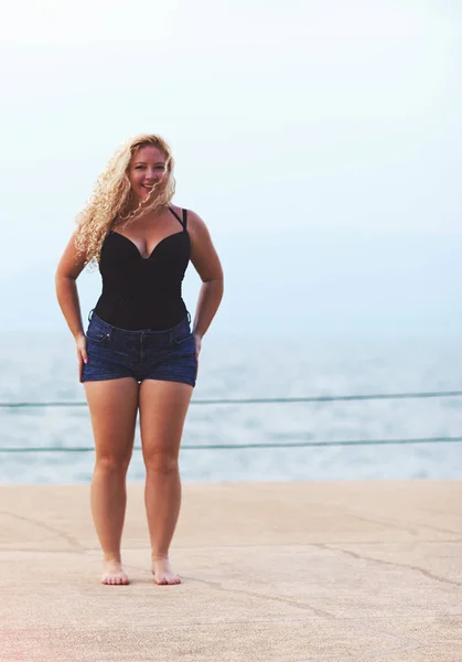 happy plus size young woman near the sea