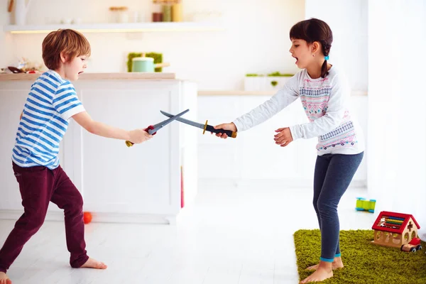 Kinder spielen aktive Kampfspiele in der heimischen Küche — Stockfoto