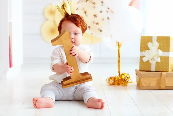 Bonito pequeno bebê menino segurando número um, enquanto sentado em festa — Fotografia de Stock