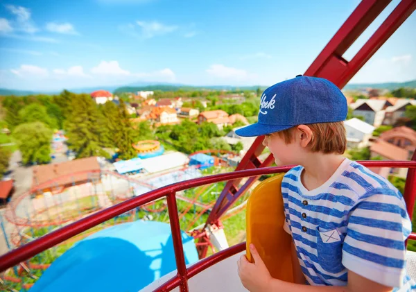 Excited boy enjoying the view from ferris wheel in amusement park — Stock Photo, Image
