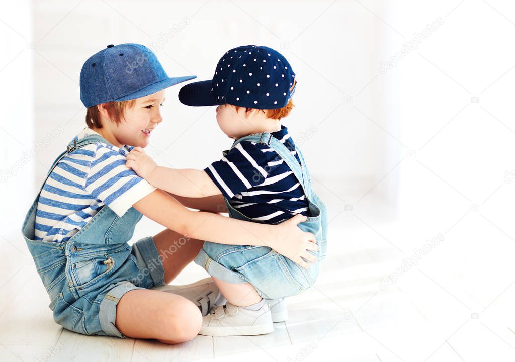 cute kids, brothers in denim jumpsuits communicating, indoors