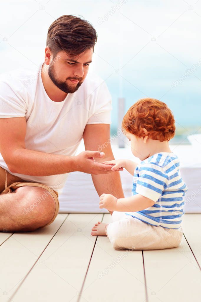 father playing with his little son on the floor