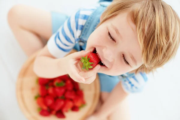 Carino bambino felice mangiare gustose fragole mature — Foto Stock
