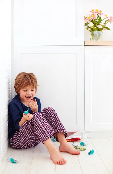 Doce dente criança escondido no canto da cozinha, comer doces — Fotografia de Stock