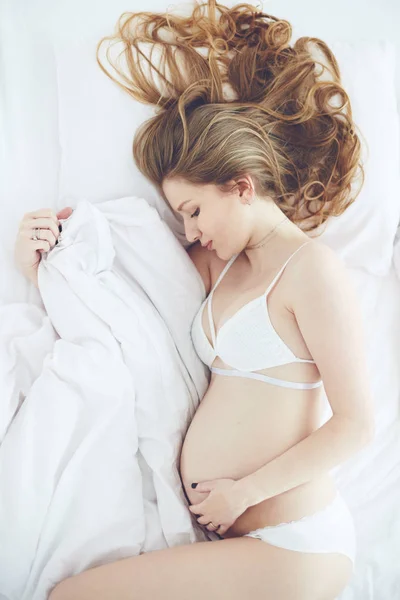 Retrato tranquilo de bela mulher grávida deitada na cama, vista superior — Fotografia de Stock
