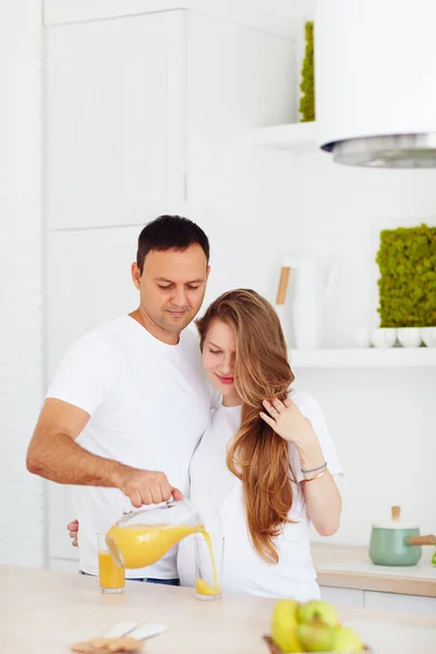 Ler gravida par dricka färsk juice på köket på morgonen — Stockfoto