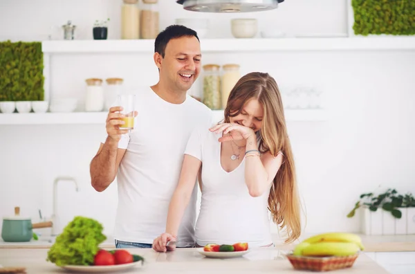 Unga gravida par ha kul, medan du förbereder frukost i köket — Stockfoto