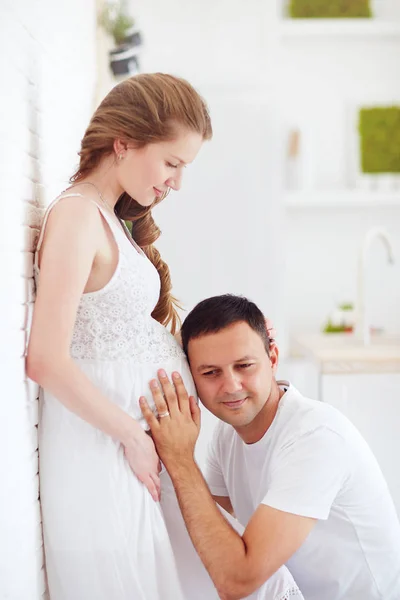 Futuro feliz papai ouvir batimento cardíaco na barriga grávida — Fotografia de Stock