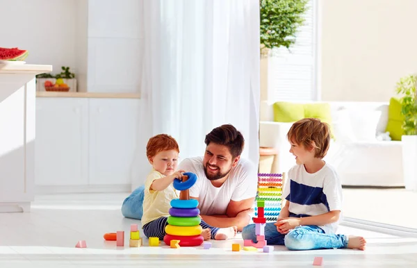 Счастливый отец играет с сыновьями дома — стоковое фото