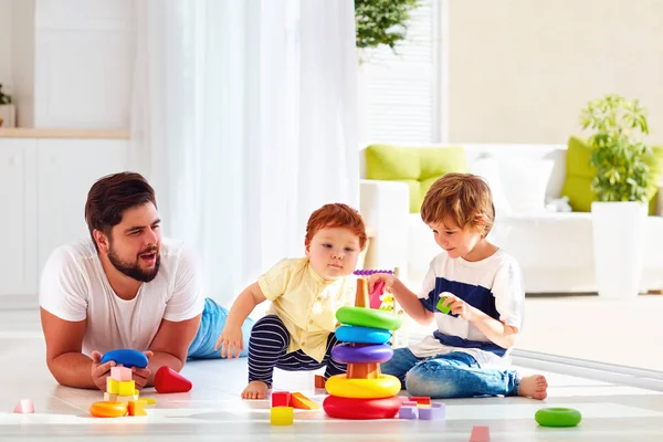 Pai feliz brincando com filhos em casa — Fotografia de Stock