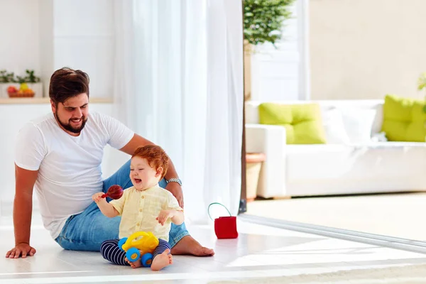 Glückliches Kleinkind spielt mit Vater zu Hause an sonnigem Sommertag — Stockfoto