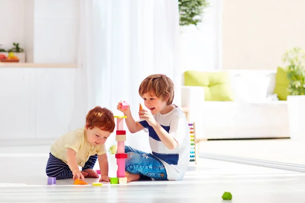 Oudere broer spelen met junior babyjongen thuis — Stockfoto