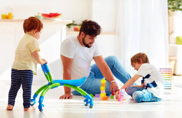 Bébé tout-petit bébé marche avec aller chariot tandis que père et enfant jouer à des jeux ensemble — Photo